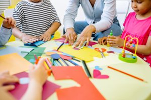 Children completing a classroom activity with colorful construction paper
