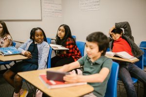 Five students sit at desks in a classroom